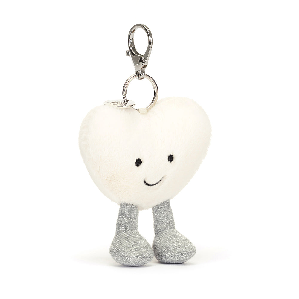 Angled View: Sweet and secure! The Jellycat Cream Heart Bag Charm in a creamy white color, perfect for personalizing your bag.