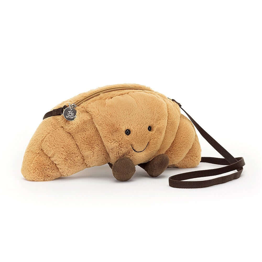 Golden Gluttony: Close-up of the Jellycat Amuseable Croissant Bag's buttery plush texture, stitched sections, and adorable cocoa cord boots.