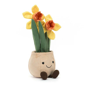Adorable Jellycat Amuseable Daffodil Pot tilted at an angle, showcasing its charming cordy boots, friendly smile, and three sunny daffodils sprouting from soft green leaves and furry "soil." Perfect for bringing springtime cheer year-round.