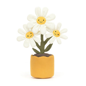 Jellycat Amuseable Daisy sits in a yellow linen pot, with brown soil. There are three flowers with cream suedette petals and each flower has a smiling face.
