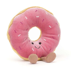 Jellycat Amuseable Doughnut tilts playfully, showing off its golden plush, berry-pink icing, rainbow stitch sprinkles, and cordy boots.