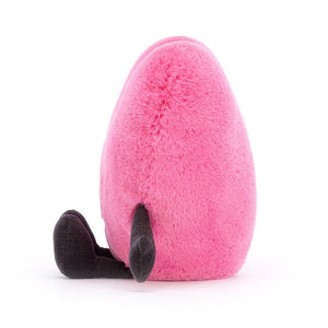 A side view of the Jellycat Amuseable Pink Heart, in a seated position with the little corded legs sitting to the front.