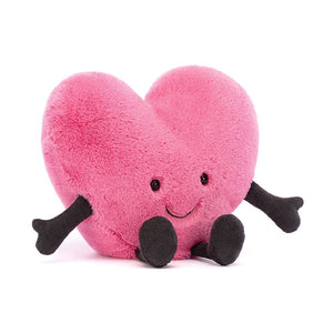 This adorable Jellycat Amuseable Pink Heart, a cuddly, vibrant pink plush heart with big, shiny eyes, a cheeky grin, and stubby cord arms and legs outstretched in a friendly wave. It's sitting up on its weighted bottom.