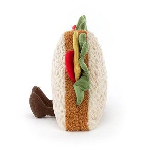 From the side the Jellycat Amuseable Sandwich with its legs sitting out in front. 