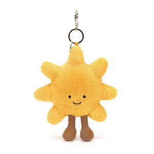 A close-up photo of the Jellycat Amuseable Sun Bag Charm, showing its smiling face, golden plush body, milk chocolate corduroy boots, and silver chain and claw clip.