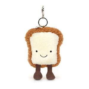 Jellycat bag charm that is in the shape of a slice of toast. It has a bag attachment on top and tiny little legs underneath. 