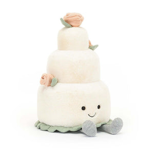 Jellycat soft children's toy in the shape of as wedding cake with dinky little feet sitting out in front.