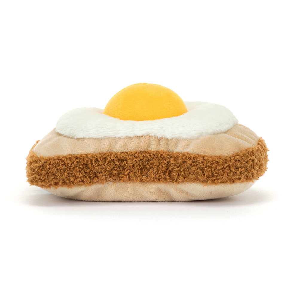 Back view of Jellycat Amuseables Egglantine Egg on Toast showing the textured golden-brown toast base and the soft, rounded design of the plush egg.