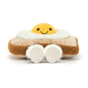 Front view of Jellycat Amuseables Egglantine Egg on Toast with Egglantine smiling atop a plush slice of toast.