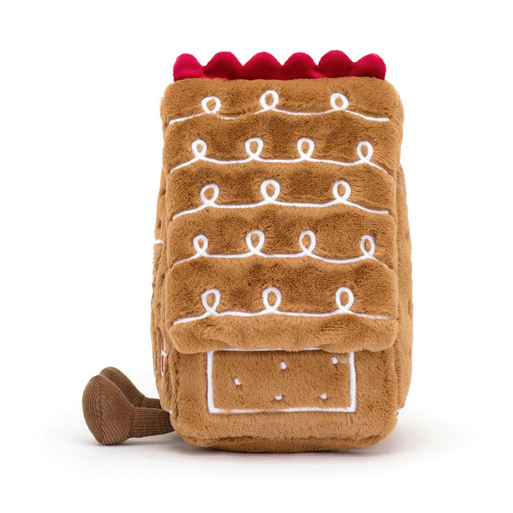 Side view of Jellycat Gingerbread House soft toy showing plush icing roof design and corduroy feet.