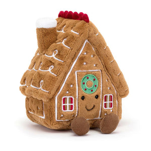 Front View: A soft, plush gingerbread house toy with a brown roof, white frosting, and colourful candy decorations.