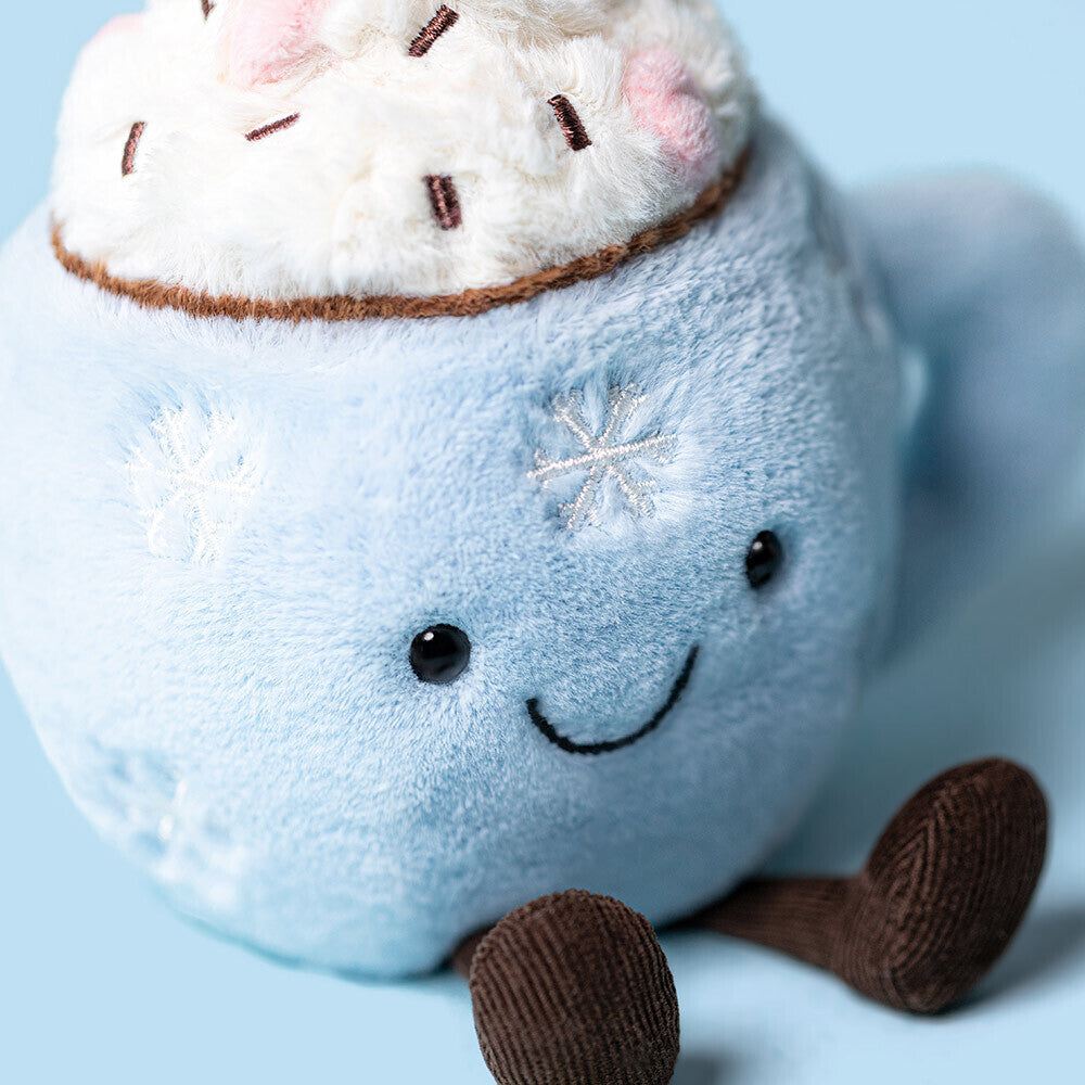 Close-up of Jellycat Hot Chocolate soft toy showing embroidered snowflakes and smiling face.