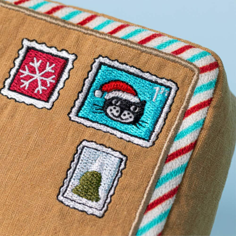 Close-up of embroidered Christmas stamps on Jellycat Amuseables Letter To Santa soft toy.