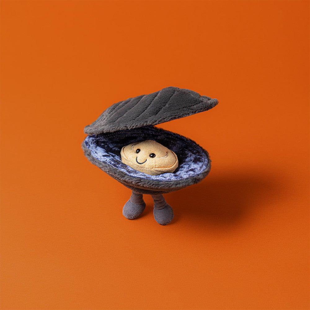 Michelle Mussel toy standing open on orange background, showing soft blue lining.