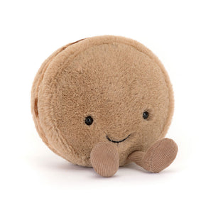 Jellycat Amuseables Mona Macaron plush, a soft biscuit-coloured macaron with an embroidered smile, corduroy legs, and a velvety texture.