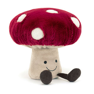 Angled View: Ready to spore-prise! The Jellycat Amuseables Mushroom leans in, showcasing its chunky red cap with creamy spots and a sturdy beige stalk. Ruched frills and a weighted base add whimsy. Perfect for imaginative play!