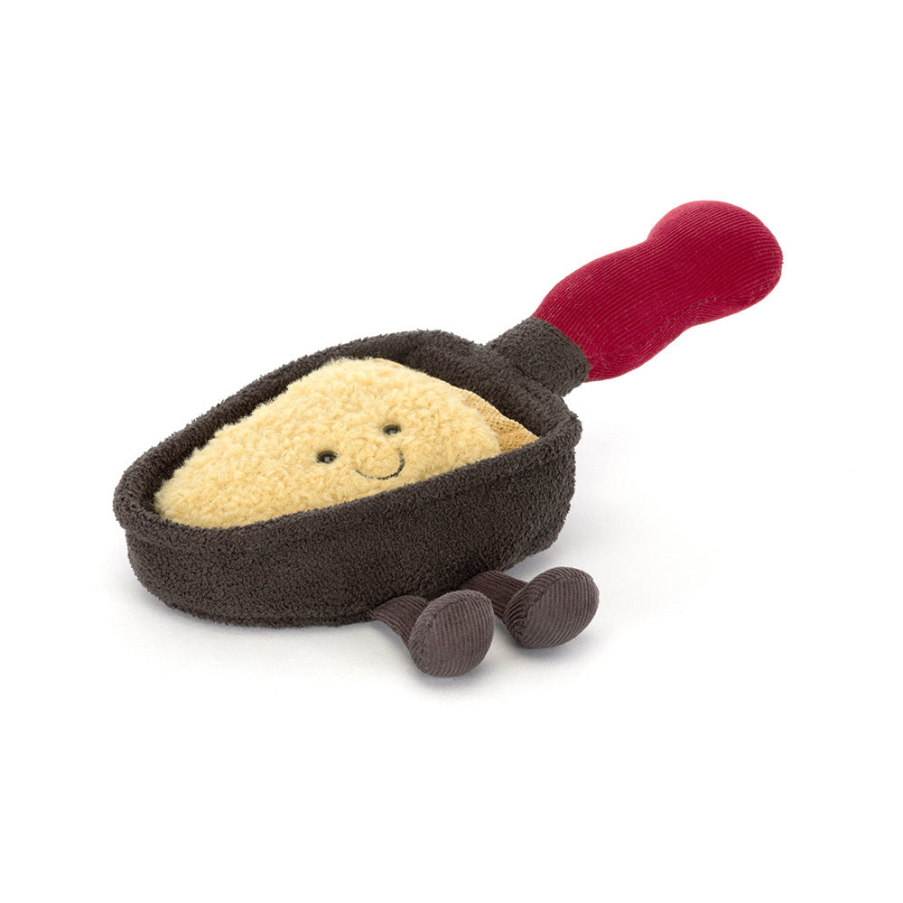 Jellycat Amuseables Raclette plush toy featuring a smiling cheese slice in a dark pan with red handle.