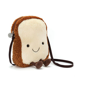 Jellycat Amuseables Toast Bag, a plush crossbody shaped like a smiling slice of toast with a fluffy brown crust, cream-coloured centre, and corduroy legs.