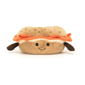 ellycat Amuseable Bagel plush toy. Soft and squishy with a stitched smile, embroidered sesame seeds, and a plush cream cheese filling with salmon. Perfect for cuddling and imaginative play.