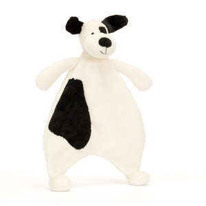 Cuddles on the Go! The Jellycat Bashful Black & Cream Puppy Comforter's lightweight design and playful pup with a blanket make it perfect for adventures. (Angled view)