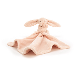  Jellycat Bashful Blush Bunny Soother. Soft pink bunny clutches the corner of a luxuriously soft, recycled plush blanket in calming blush pink.