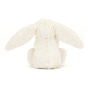 Sleepytime Security: The Jellycat Bashful Cream Bunny Soother's soft bunny cozies up behind its rolled-up blanket, creating a warm and comforting haven for little ones.
