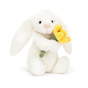 Sunshine & hugs! Bashful Bunny holds a cheery daffodil. This soft pal, with its double-cream fur, symbolizes new beginnings & makes a perfect gift.
