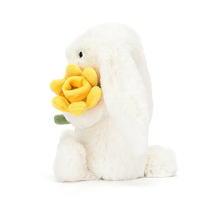 See the playful details of Bashful Daffodil Bunny! This soft friend features a fluffy tail, a cheery daffodil & is perfect for cuddly adventures.