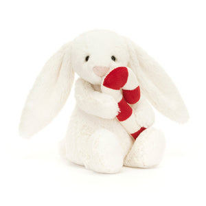 Product slightly to an angle: Jellycat Bashful Bunny plush toy with candy cane, shown in profile, highlighting its festive colours.