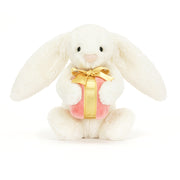 Front-On: Soft and floppy Jellycat Bashful Bunny cradles a beautifully wrapped present, perfect for gifting or cuddling.