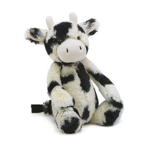 Jellycat Bashful Calf has creamy white and black patchy fur and two short white horns. 