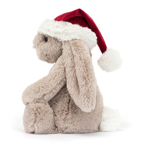 Side View: Softness & Holiday Cheer! The Jellycat Bashful Christmas Bunny boasts soft fur, floppy ears & a festive red hat.