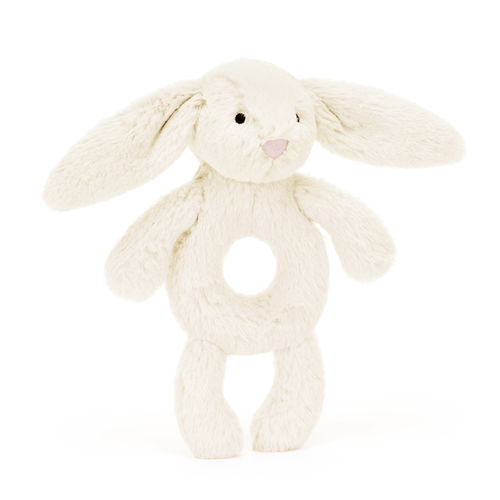 At An Angle: Sensory exploration at its finest! The Jellycat Bashful Cream Bunny Ring Rattle combines soft plush with a textured teething ring, perfect for little hands.