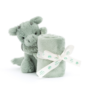 Jellycat Bashful Dragon Soother holding a  neatly rolled soother tied with a baby Jellycat ribbon.