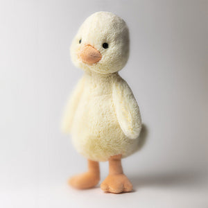 Lifestyle Shot: Jellycat Bashful Duckling standing upright against a neutral background, showing off its fluffy texture.