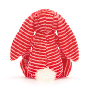 Behind: Back view of Jellycat Bashful Evey Bunny plush toy, showing the full length of its fluffy tail and the red and cream stripes.