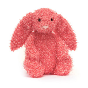 Product slightly to an angle: Jellycat Bashful Holly Bunny plush toy in profile, showing its curly red and white fur.