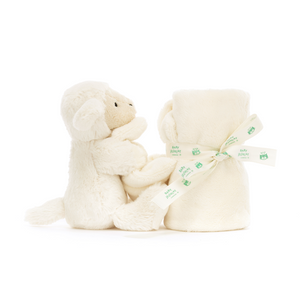 Jellycat Bashful Lamb Soother from the side, emphasizing its soft vanilla cream fur and neatly rolled presentation tied with a Baby Jellycat grosgrain ribbon.