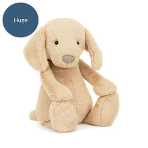 Image 1 (Seated Angled View - Huge): The Jellycat Bashful Luxe Puppy Orlando in huge size, sitting at an angle with floppy ears and a soft plush body.