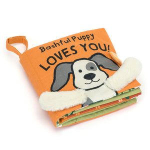 Angled View:  Bashful Puppy Loves You: A playful puppy dog cloth book with colorful pictures, crinkly textures, and lift-up flaps to engage your baby's senses.