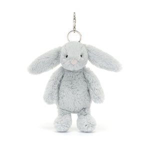 A soft, silver-grey Jellycat Bashful Bunny bag charm with long floppy ears, a white fluffy tail, and a gentle smile. Attached to a silver keyring and clip.