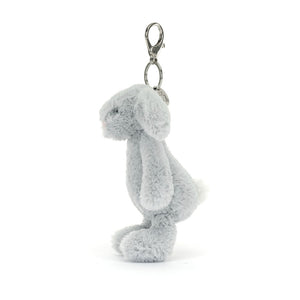 A side profile of the Jellycat Bashful Silver Bunny bag charm, showcasing its plush fur, floppy ears, and tiny white tail. The silver clip is visible at the top.