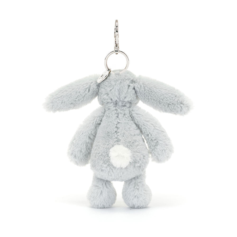 The rear view of the Jellycat Bashful Silver Bunny bag charm, displaying its fluffy white tail, long ears, and a soft grey body. The silver keyring and clip are attached at the top.