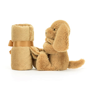 On-the-go comfort! The Jellycat Bashful Toffee Puppy Soother is lightweight and perfect for cuddling on the move. (Blanket wrapped up, side view)