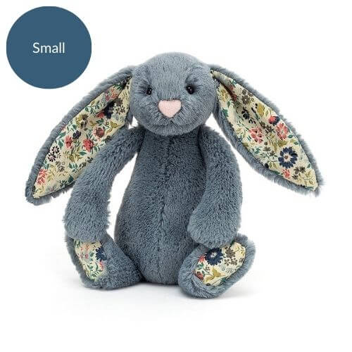 Chalky blue Jellycat Blossom Bunny sits patiently, showcasing charming blossom ears and velvety soft fur - a timeless hug waiting to happen.