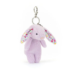 Fuzzy purple Jellycat Jasmine Bunny charm peeks out with fluffy tail & colorful ears - a cute companion for every adventure