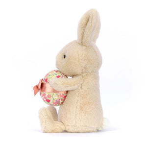 Side profile of Jellycat Bonnie Bunny with Egg, highlighting the bunny’s soft fur, floppy ears, and pastel egg accessory.