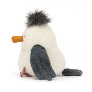 Playful Jellycat Chip Seagull perched on its side, showcasing its fluffy wings.