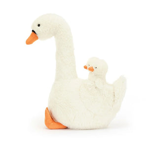 A side Image of Jellycat Featherful Swan, a luxuriously soft, plush swan with creamy white fur and bright orange accents. The swan has suedette feet and beak, and piping details. Two tiny cygnets are nestled within the swan's wings.