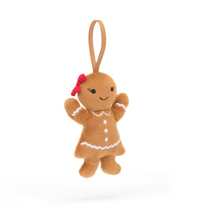 Jellycat Gingerbread Ruby Christmas (angled view): Gingerbread cookie plush with red bow, embroidered lashes & loop.